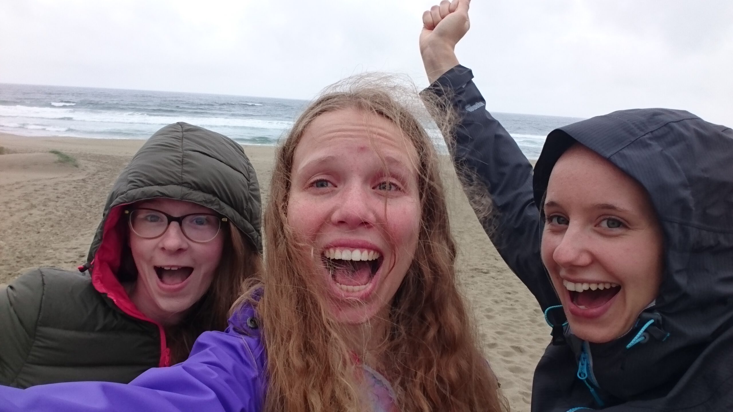 Three girls at the beech (it's cold though) cheering