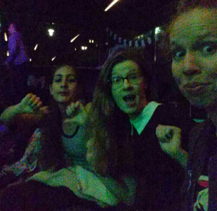 Three girls in terrible lighting fake cheering for a lame halloween party