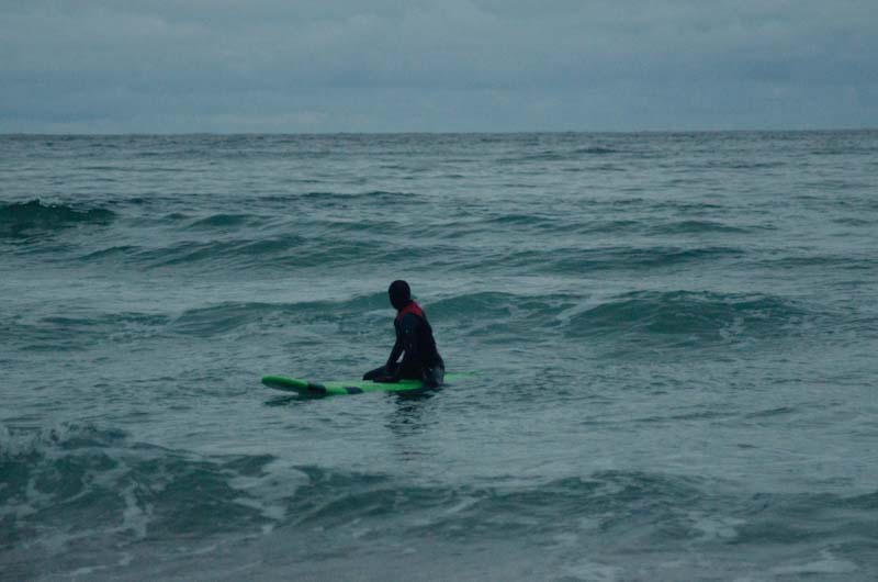 Eine Surferin wartet nachts auf eine Welle.